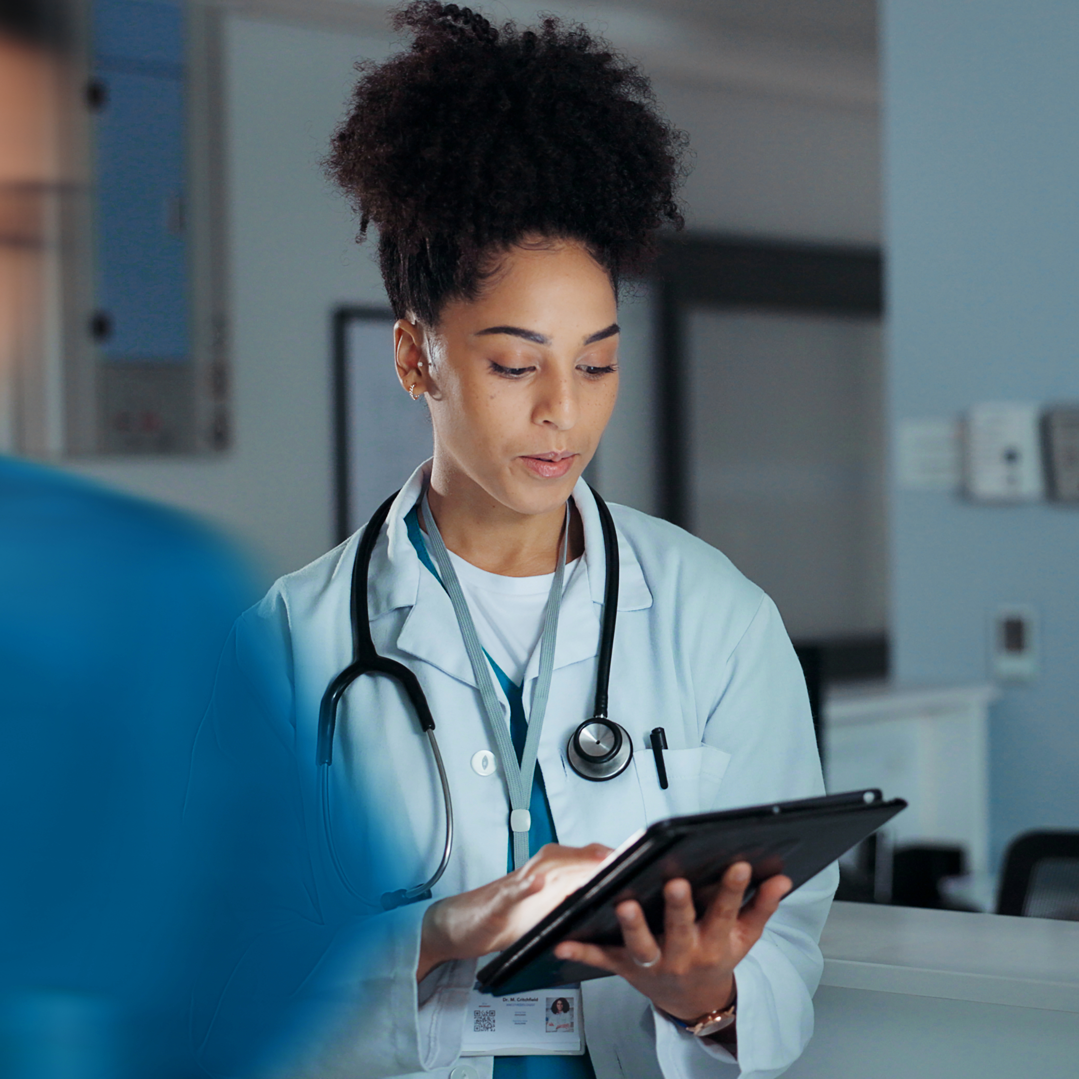 A woman looking down at a tablet.